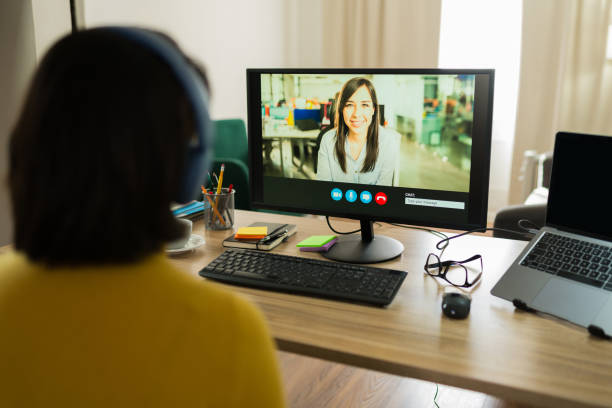 istock Freelancer wearing noise-canceling headphones participating in virtual team meeting, working remotely from home workspace 2199120633