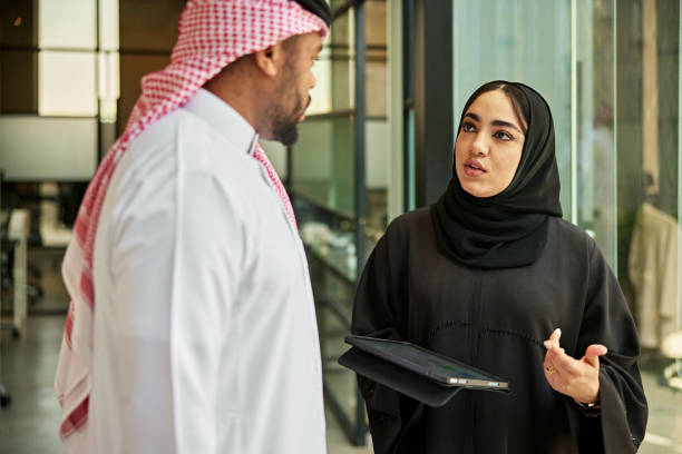 istock Riyadh business associates conversing in office hallway 2199120951