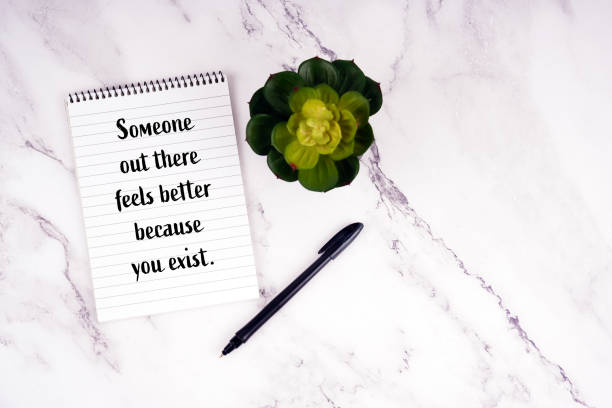 istock Motivational quote. Someone out there feels better because you exist. Written on a notebook 2199121819