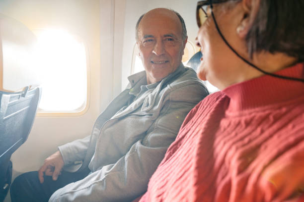 istock Senior Couple Riding In An Airplane 2199125501