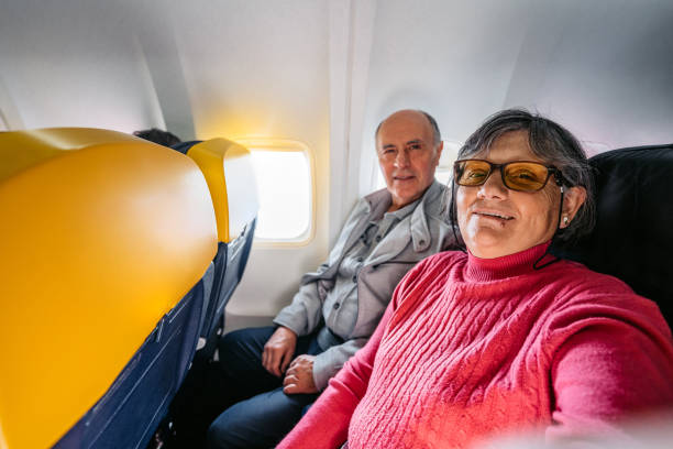 istock Senior Couple Taking Selfies While Riding In An Airplane 2199125654