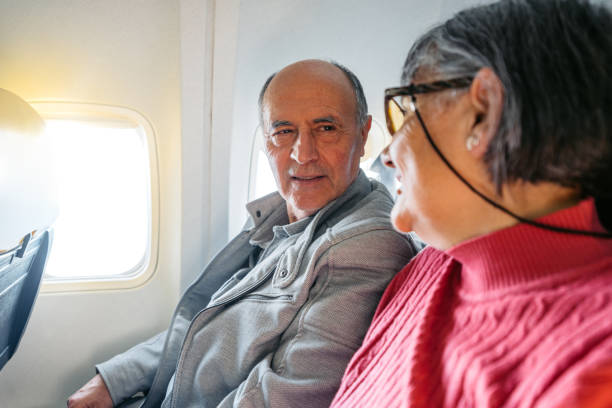 istock Senior Couple Riding In An Airplane 2199125734