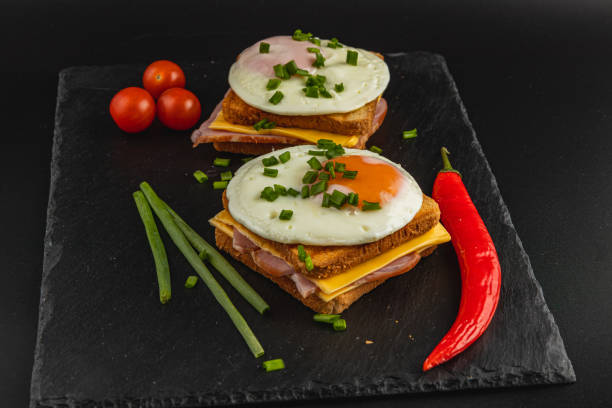 istock Tasty breakfast sandwich with eggs, ham, and fresh veggies on slate 2199126902