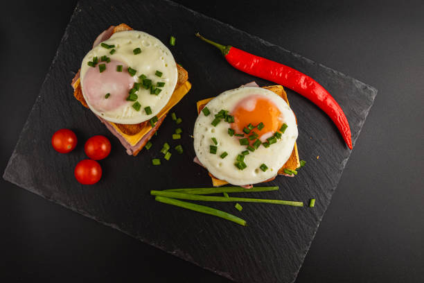 istock Delicious brunch with toasted bread, eggs, and fresh toppings on black slate 2199127120