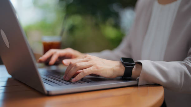 istock Beautiful Asian businesswoman working on laptop while using artificial intelligent mobile app on her smart watch to get help with her work in downtown financial district in Tokyo 2199128789