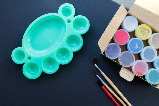 istock Paint brushes and paints on a black background. Top view. 2199129169