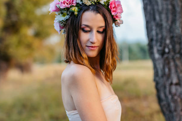 istock Young Woman Wearing A Flower Crown While Standing In The Field 2199129202