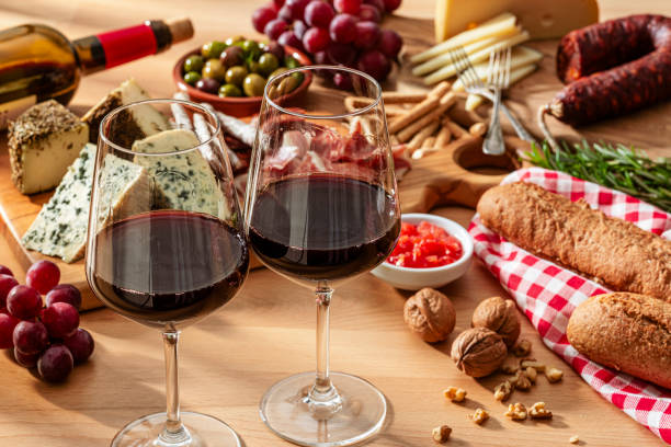 istock Spanish food: two red wine glasses and   tapas on wooden table 2199130941