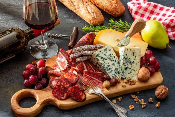 istock Deliscious appetizer: cheese, Serrano ham and chorizo board, red wine and fruits 2199130943