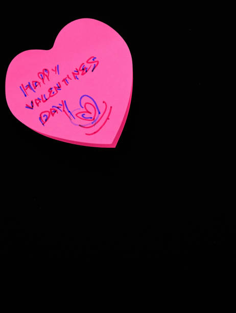 istock Heart-shaped pink paper note inscribed with 