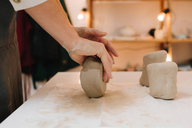 istock Female potter rolls piece of clay before sculpting. Preparing clay for making ceramic crockery. 2199134923