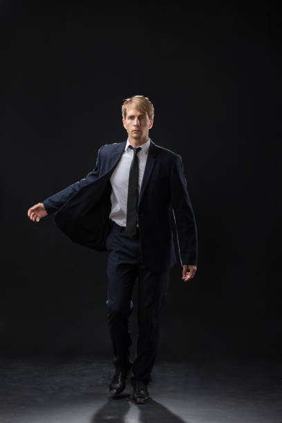 istock confident man strides forward in a dark suit, exuding authority 2199134946