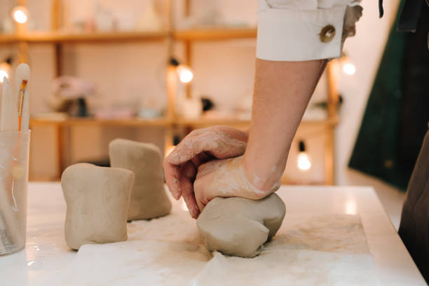 istock Female potter rolls piece of clay before sculpting. Preparing clay for making ceramic crockery. 2199135234