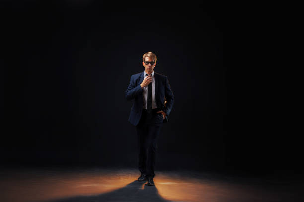 istock confident man strides forward in a dark suit, exuding authority 2199135291