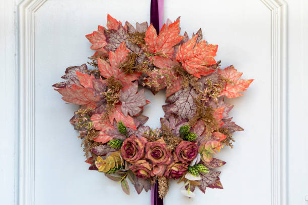 Wreath of autumn leaves hanging on a white door