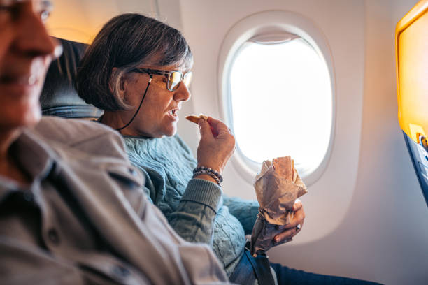 istock Senior Woman Eating A Sandwich While Riding In An Airplane 2199136637