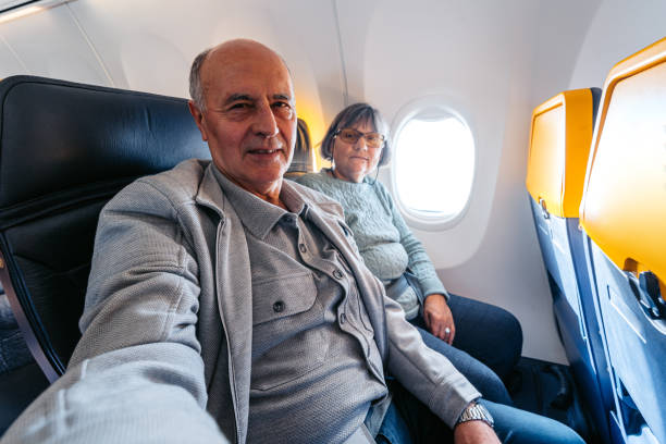 istock Senior Couple Taking Selfies While Riding In An Airplane 2199136783