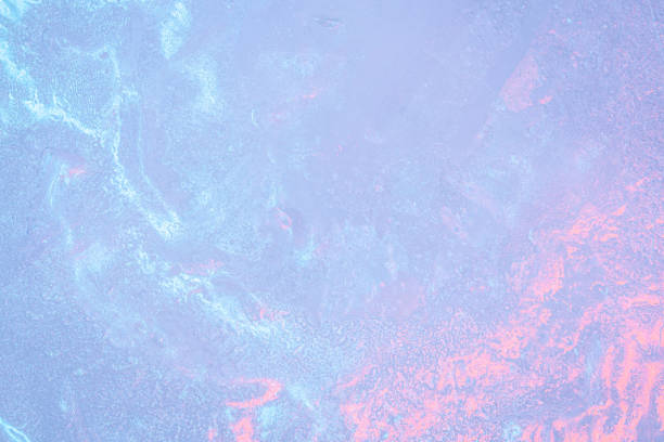 The surface showcases a captivating blend of icy textures, with subtle variations in color ranging from cool blues to warm pinks, reflecting the beauty of twilight.