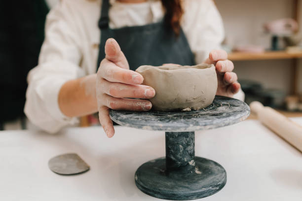 istock Process of creating ceramic products. Female potter hands shows ceramic bowl ready for firing in a kiln. 2199137286
