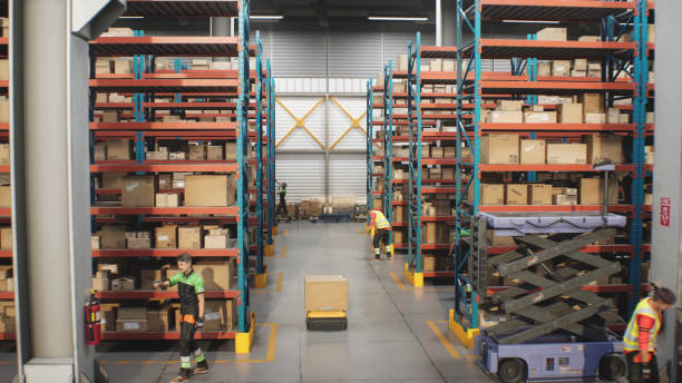 istock AGV Robots Transporting Cardboard Boxes, Parcels in Warehouse, Workers Managing Inventory 2199138922