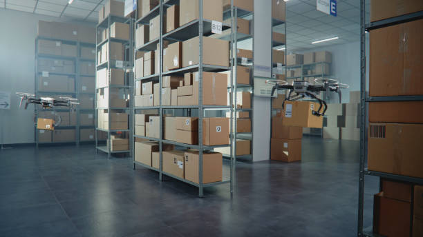 istock Logistics Distribution Center: UAV Drones Carrying and Delivering Cardboard Boxes 2199139753
