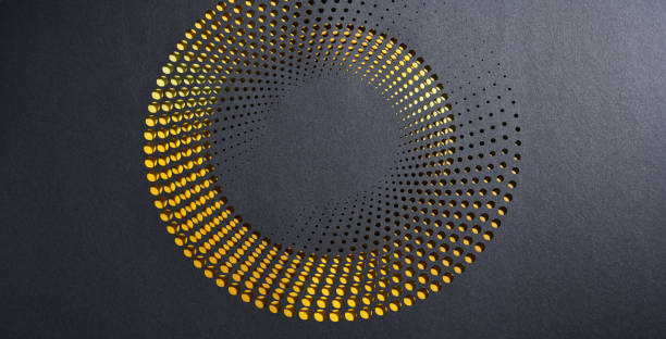 istock Modern abstract paper cutout artwork with circular perforations revealing a golden layer on a dark background. 2199140152