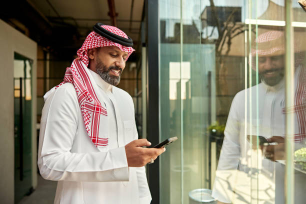 istock Saudi professional checking smart phone and smiling 2199140544