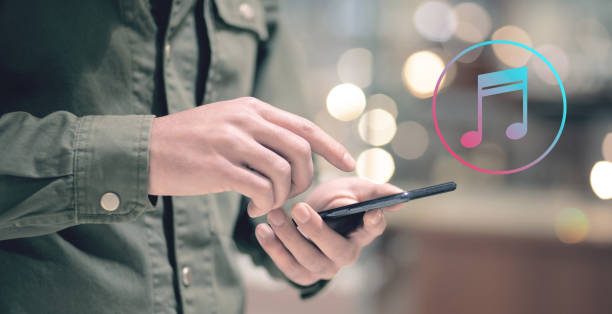 istock musical icon. Man holding a phone in his hand 2199143699