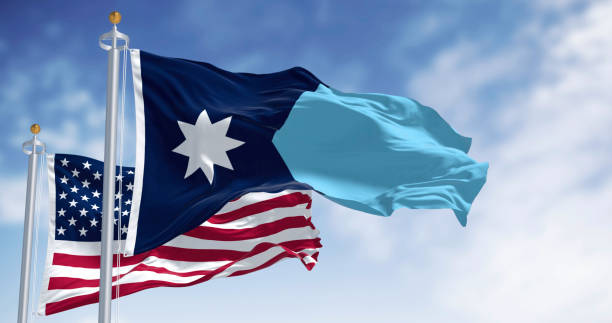 istock Minnesota and USA flags waving on a clear day 2199144090