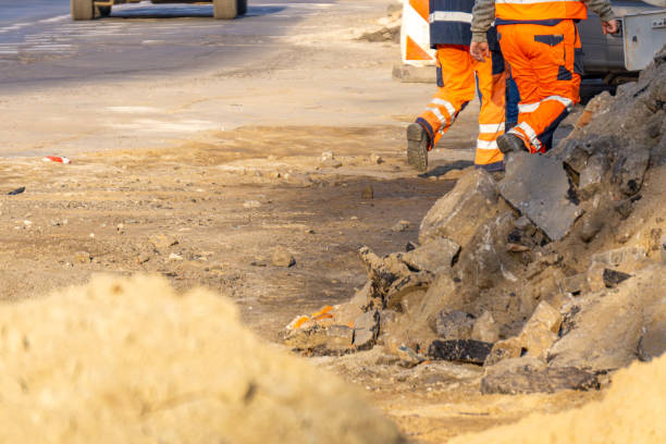 istock road workers at work. road and construction workers in orange vests. earthworks being done in the city during road construction. 2199144742