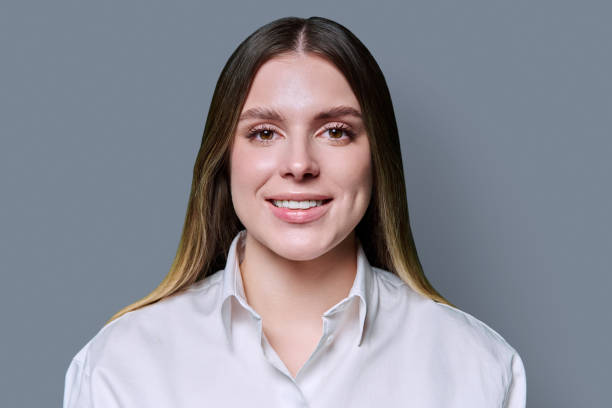 istock Headshot portrait young smiling woman on grey studio background 2199145494