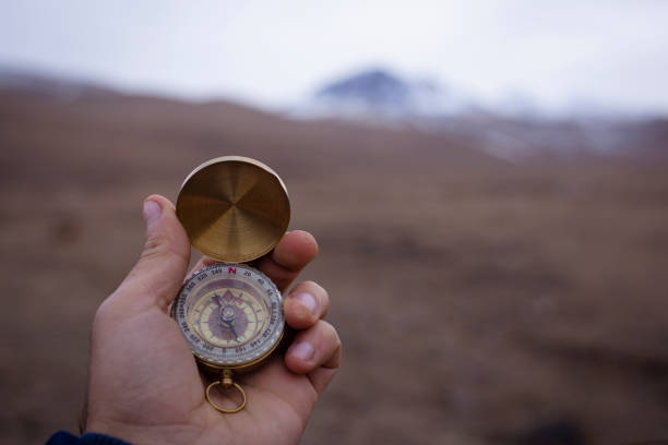 istock Holds a compass against the backdrop of a mountain 2199146228