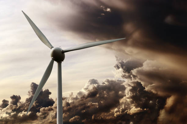 Wind turbine at sunset in front of a dramatic sky with storm clouds