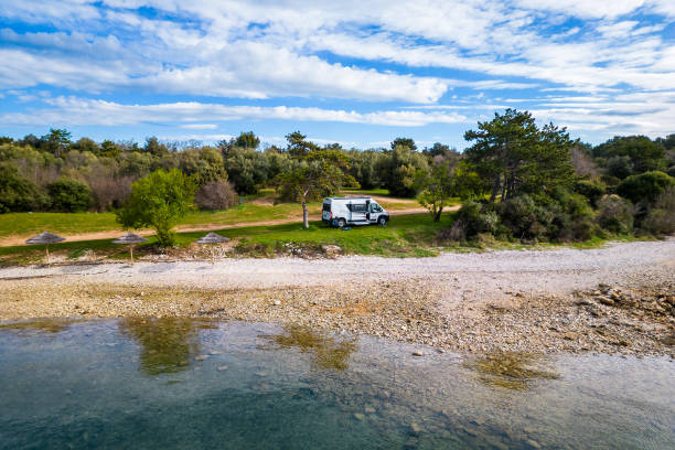 istock Camper van or motor home is parked on a beach in the Mediterranean sea. 2199146610
