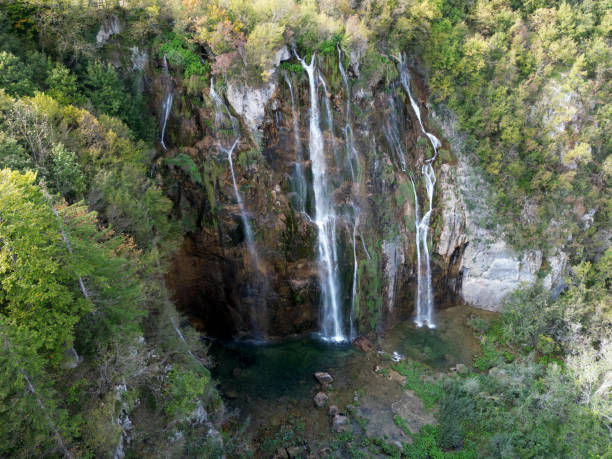 istock Beauty in spring nature, amazing waterfall in forest. Waterfall and pond. Panoramic beautiful deep forest waterfall. Beautiful view to waterfalls with green forest. The tranquil waters of waterfalls. 2199150410