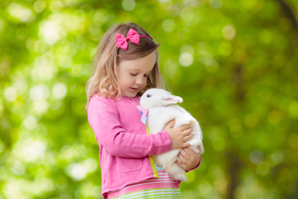 istock Little girl playing with rabbit 2199150443