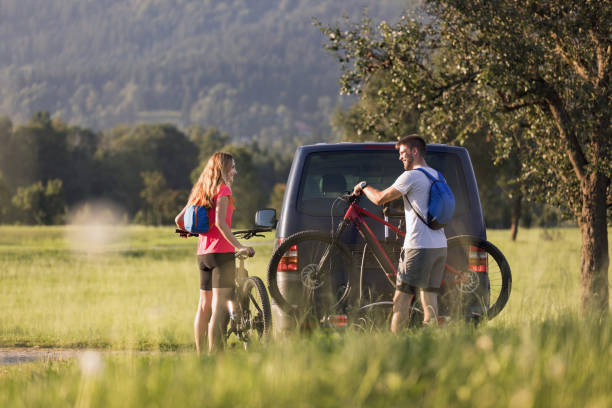 istock Couple taking down electric mountain bikes from van 2199150862