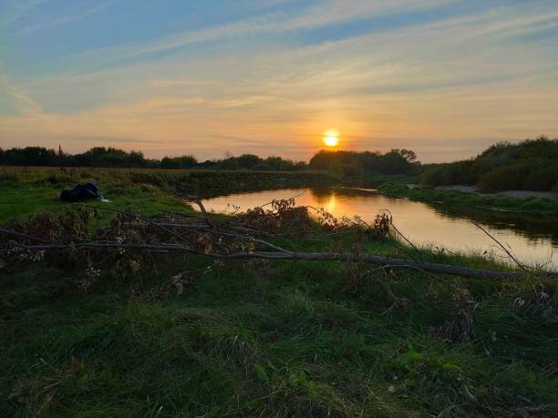 istock Scenic Riverbank at Sunset with a Warm Glow 2199152908