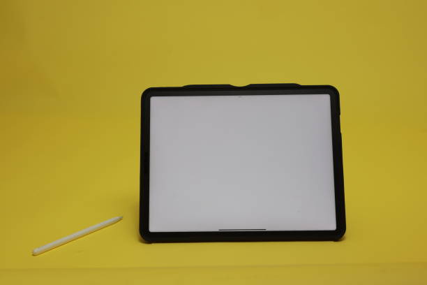Digital tablet and a digital pen with a white screen on a yellow background.