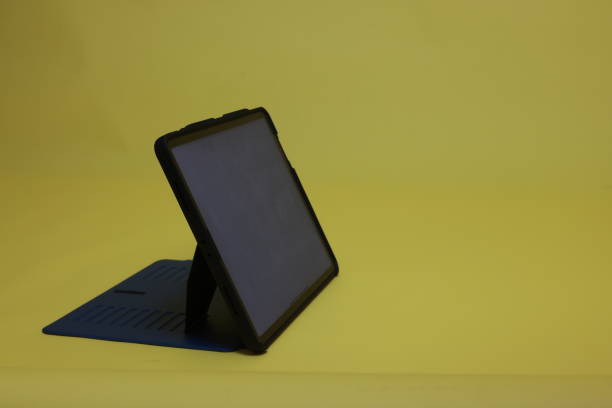 istock Digital tablet and a digital pen with a white screen on a yellow background. 2199154037
