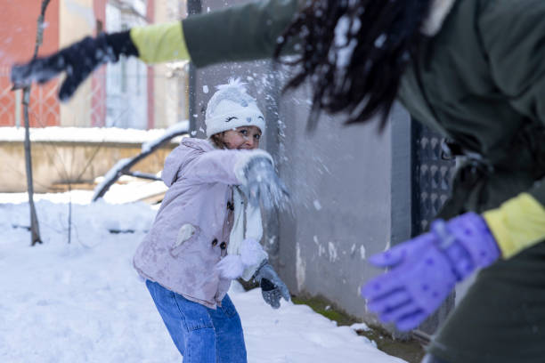 istock Girls playing snowball fight 2199157413