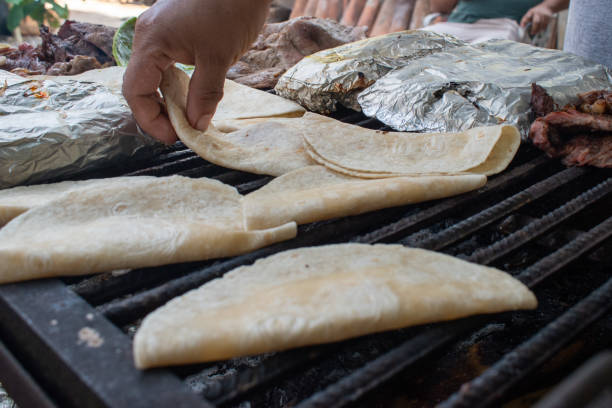 istock Hand flipping quesadillas on a grill during preparation 2199157463
