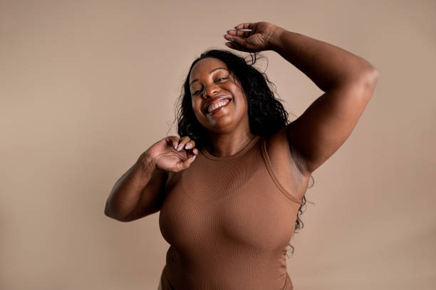 istock Mature woman dancing on a beige background 2199160743