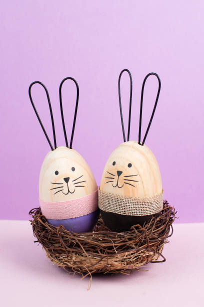 istock Easter bunny or rabbit couple cuddle together in wicker nest, wooden egg, spring holiday greeting card 2199168961