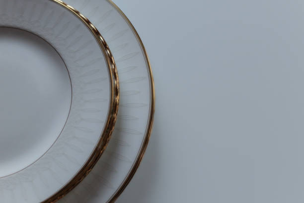 elegant fine china dinnerware plates isolated on a table background. close-up formal dinner backdrop empty blank template with space for copy.