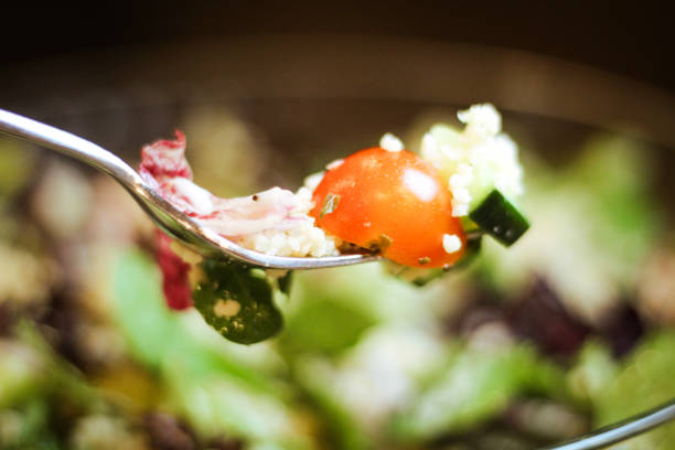 Fresh lettuce and tomato on a fork.