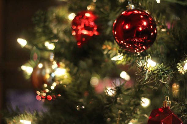 istock Traditional Christmas tree with lights and reflective ornaments gold bokeh effect background close-up photography 2199170446