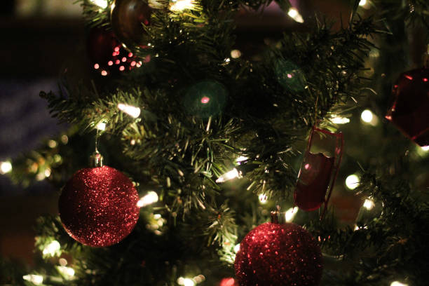 Christmas tree with lights bokeh effect background. New Year s backdrop ornaments glowing traditional warm glowing greenery backdrop.