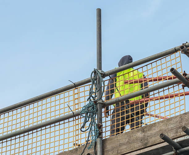 istock Building work being undertaken at high level with scaffolding. One person/builder standing on the scaffold support 2199175832