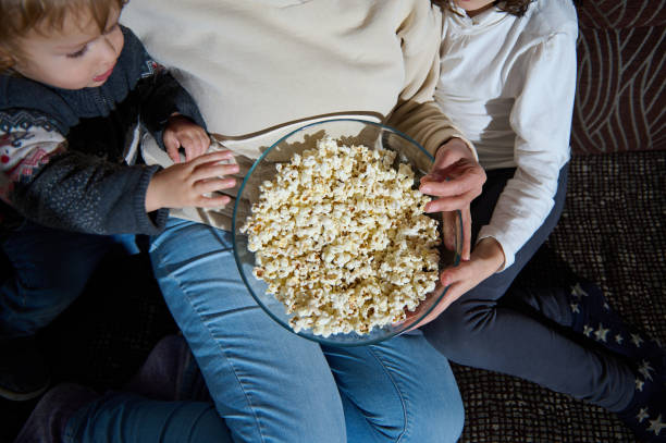 istock Family Sharing a Bowl of Popcorn While Enjoying Quality Time Together 2199176338